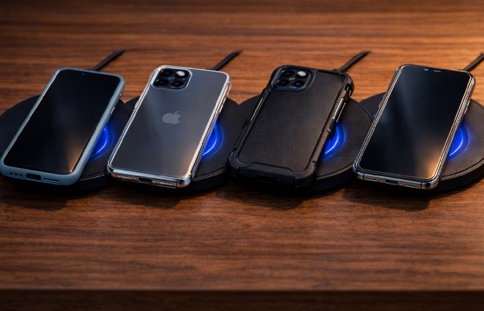 Smartphones with different case types placed on wireless chargers
